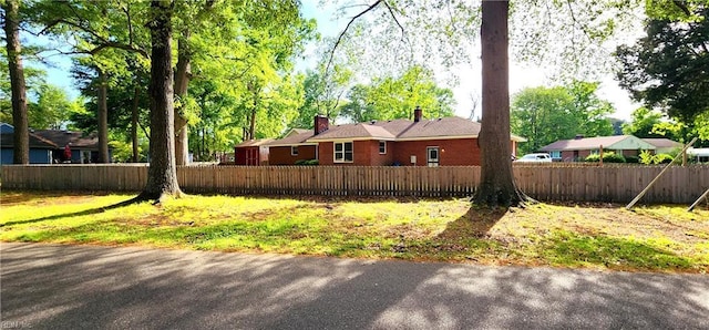 view of property exterior with fence private yard and a chimney