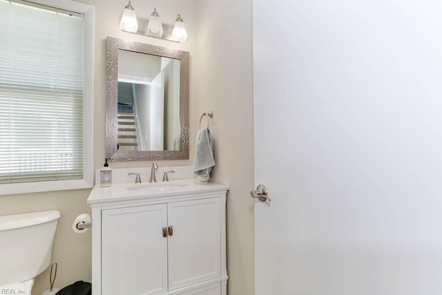 half bathroom with vanity and toilet