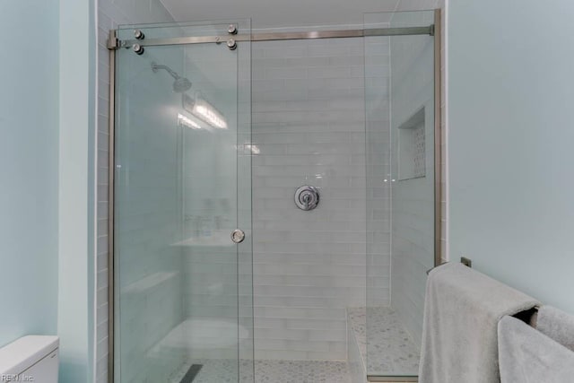 bathroom featuring toilet and a stall shower