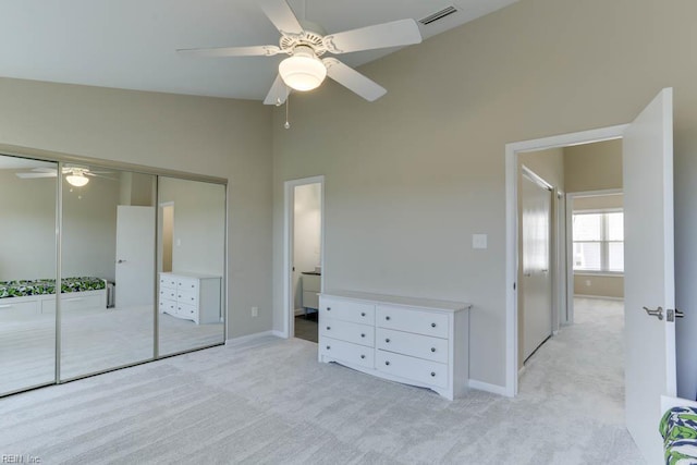 unfurnished bedroom featuring baseboards, light colored carpet, visible vents, and a closet