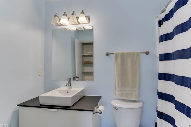 full bath with vanity, a shower with shower curtain, and toilet