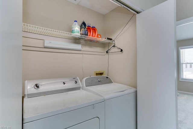 clothes washing area featuring separate washer and dryer, laundry area, and light colored carpet