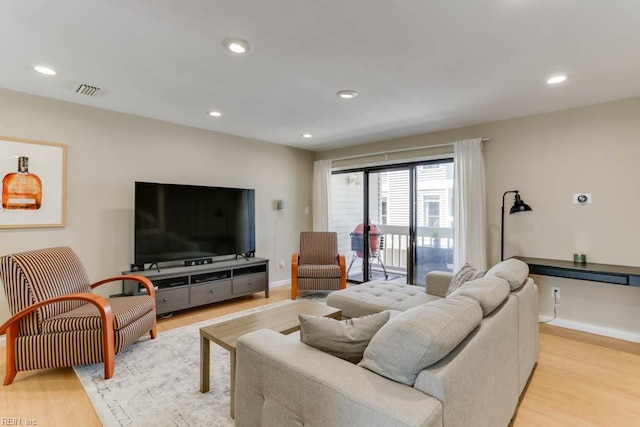 living room featuring recessed lighting, baseboards, visible vents, and light wood-style flooring