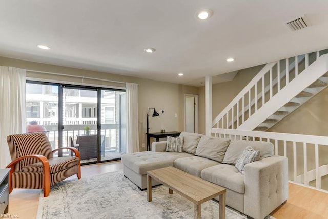 living area with recessed lighting, visible vents, and light wood finished floors