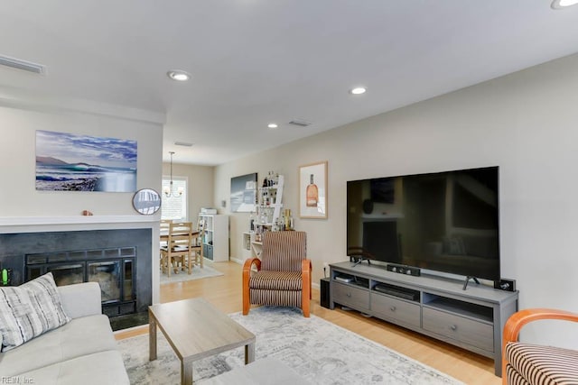 living area featuring a chandelier, recessed lighting, wood finished floors, and visible vents