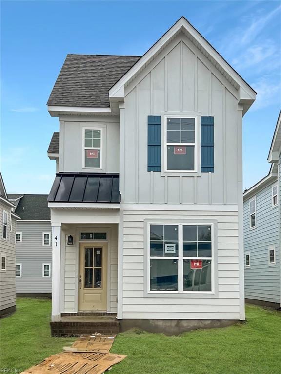 modern farmhouse style home with a standing seam roof, board and batten siding, and a front yard