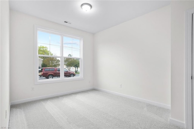 empty room featuring baseboards, visible vents, and carpet