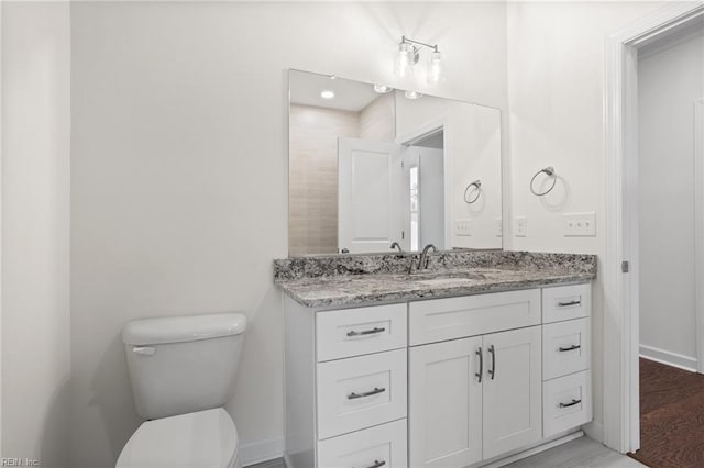 bathroom featuring vanity, baseboards, and toilet