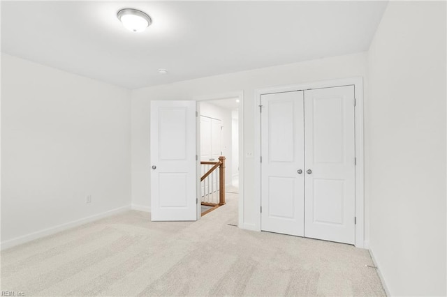 unfurnished bedroom with baseboards, carpet flooring, and a closet
