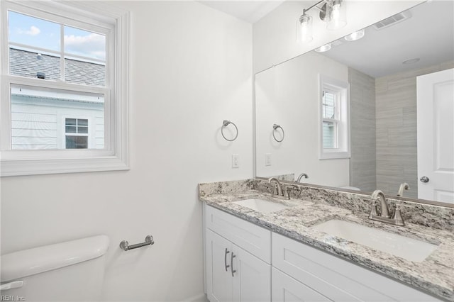 full bath featuring visible vents, a sink, a wealth of natural light, and toilet