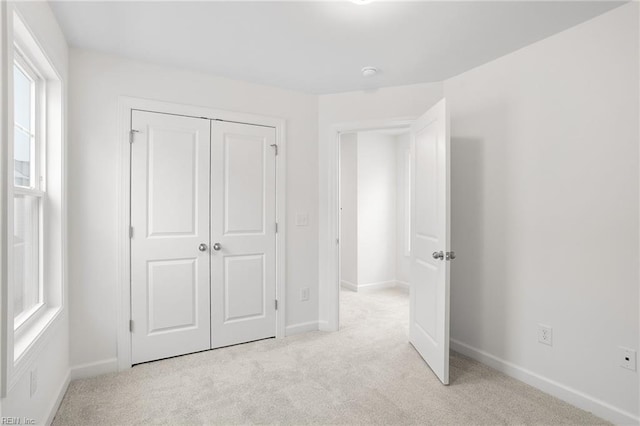 unfurnished bedroom with baseboards, carpet, and a closet