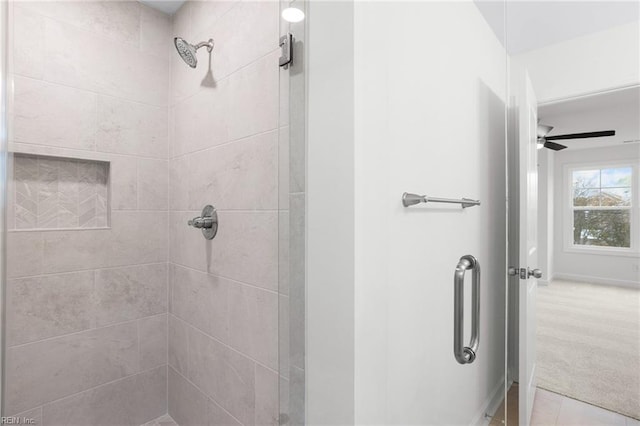 bathroom with baseboards, tile patterned flooring, ceiling fan, and a stall shower
