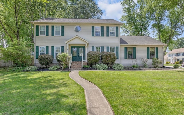 colonial-style house featuring french doors and a front yard