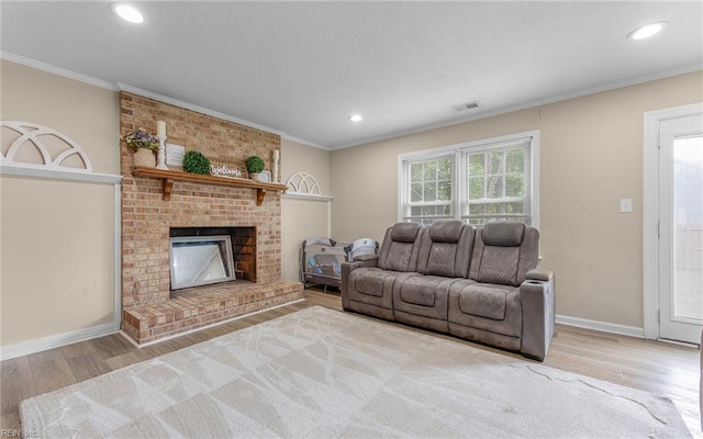 living area featuring crown molding, baseboards, wood finished floors, and visible vents