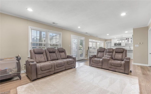 living room featuring crown molding, recessed lighting, wood finished floors, and visible vents