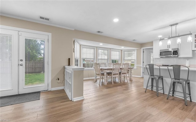dining room with visible vents, baseboards, french doors, and light wood-type flooring