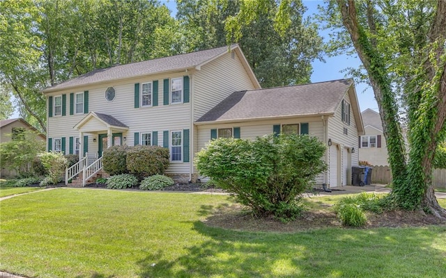 colonial home featuring a garage and a front lawn