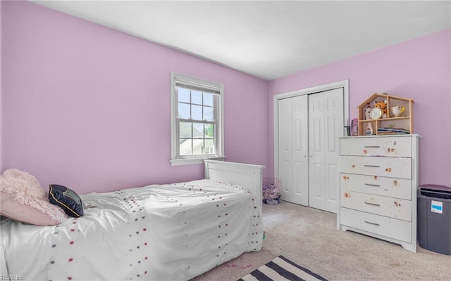 bedroom featuring light colored carpet and a closet