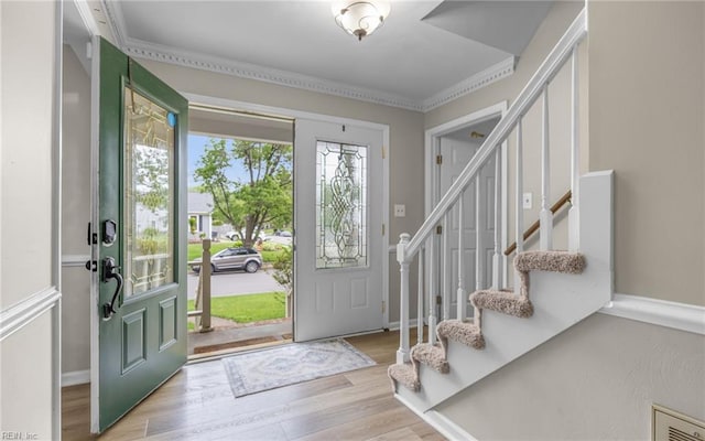 foyer entrance with stairway, wood finished floors, and visible vents