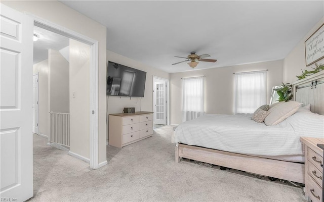 bedroom featuring baseboards, light colored carpet, and ceiling fan