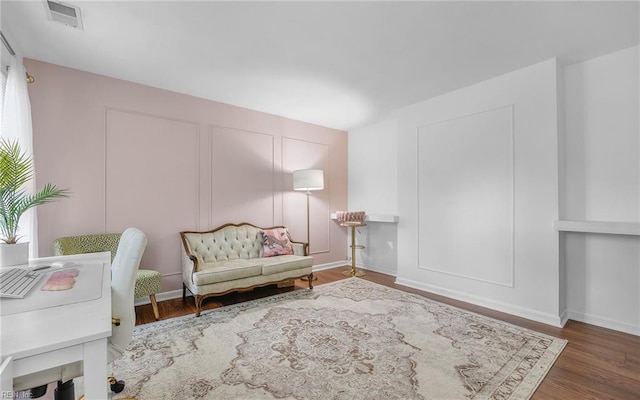 sitting room featuring wood finished floors and visible vents