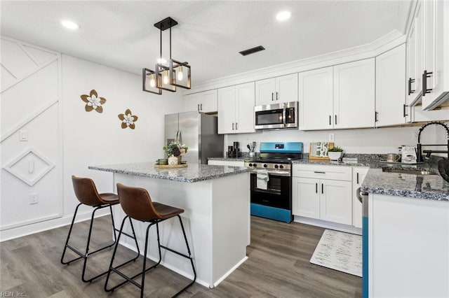 9 W Bayberry Ct, Hampton, VA 23669 - kitchen featuring visible vents, a kitchen island, white cabinets, a sink, and appliances with stainless steel finishes