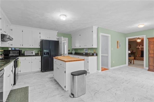 kitchen with butcher block countertops, white cabinetry, under cabinet range hood, a kitchen island, and black appliances