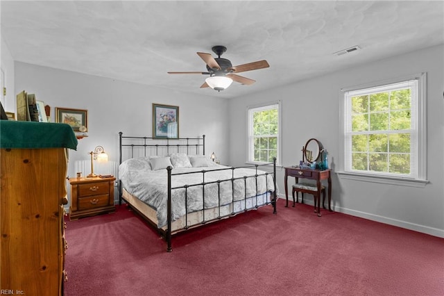 bedroom with baseboards, visible vents, ceiling fan, and dark colored carpet