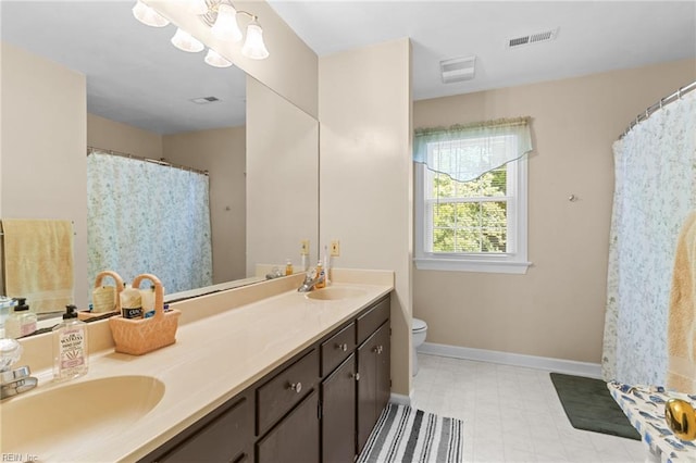 full bath featuring double vanity, toilet, baseboards, and a sink