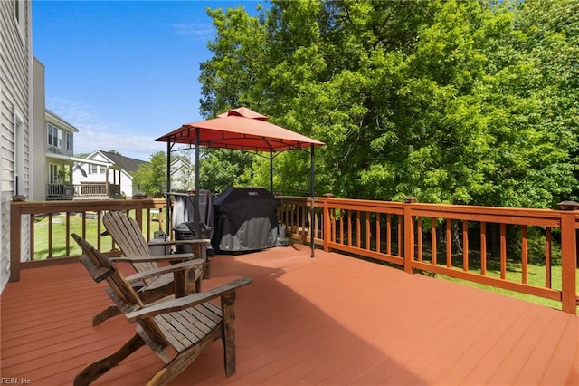 wooden deck featuring grilling area and a gazebo