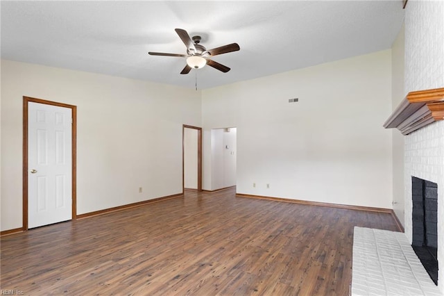unfurnished living room with ceiling fan, visible vents, a brick fireplace, wood finished floors, and baseboards