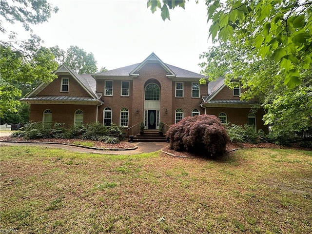 view of front of home featuring brick siding and a front yard