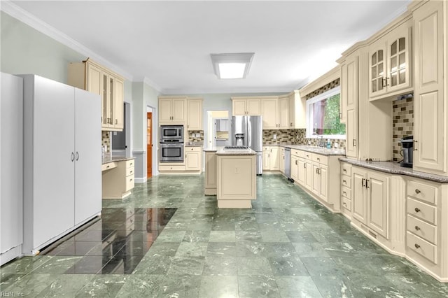 kitchen with crown molding, appliances with stainless steel finishes, backsplash, and cream cabinets