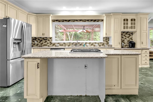 kitchen featuring a center island, tasteful backsplash, cream cabinets, and stainless steel appliances