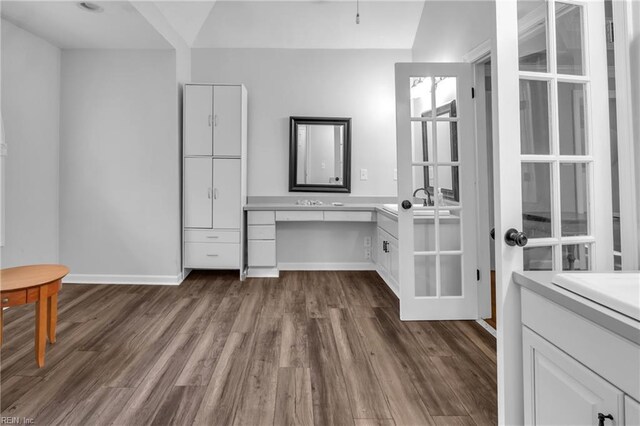 interior space featuring vanity, baseboards, and wood finished floors