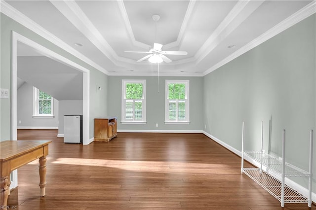 unfurnished living room featuring crown molding, ceiling fan, hardwood / wood-style floors, baseboards, and a tray ceiling