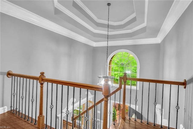 corridor featuring crown molding, an upstairs landing, and a raised ceiling