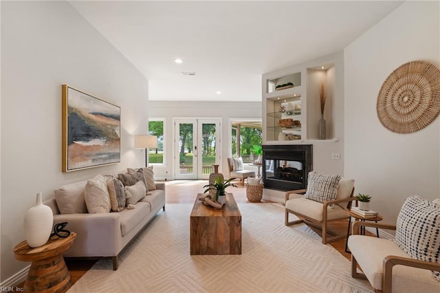 living room with a multi sided fireplace, recessed lighting, visible vents, and french doors
