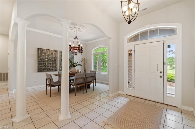 entrance foyer featuring baseboards, decorative columns, light tile patterned floors, and a notable chandelier