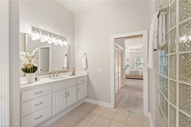 bathroom featuring tile patterned floors, baseboards, vanity, and connected bathroom
