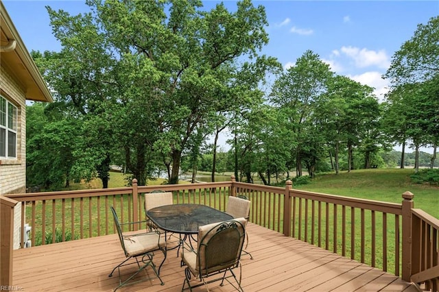 wooden deck with a lawn and outdoor dining area