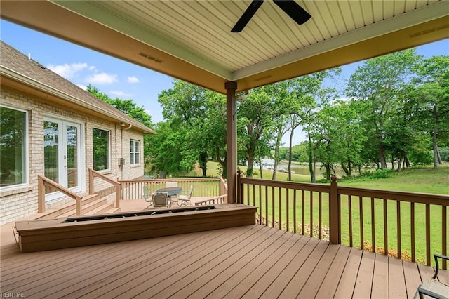 wooden terrace with french doors, a ceiling fan, a yard, and visible vents
