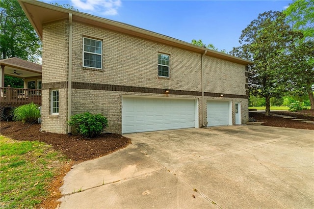 view of side of property with an attached garage, driveway, and brick siding