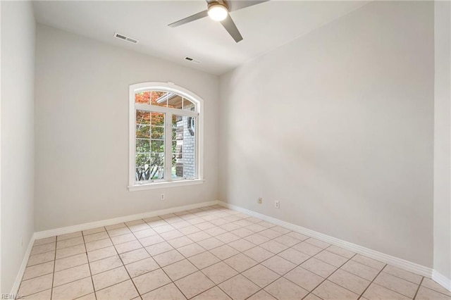 spare room featuring light tile patterned floors, baseboards, ceiling fan, and visible vents