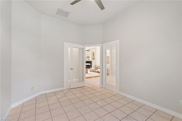 empty room with visible vents, baseboards, ceiling fan, and light tile patterned flooring