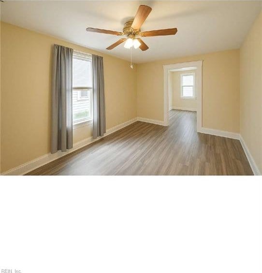 unfurnished room featuring light wood-style floors, a ceiling fan, and baseboards