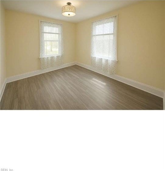 empty room with baseboards and wood finished floors