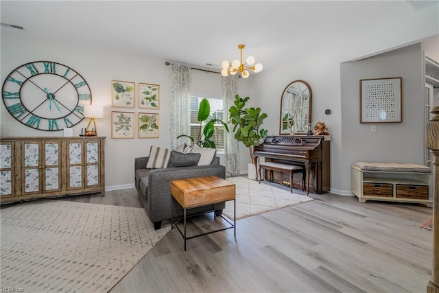 sitting room with an inviting chandelier, baseboards, wood finished floors, and visible vents