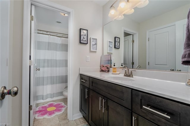 full bathroom featuring vanity, baseboards, a shower with shower curtain, and toilet