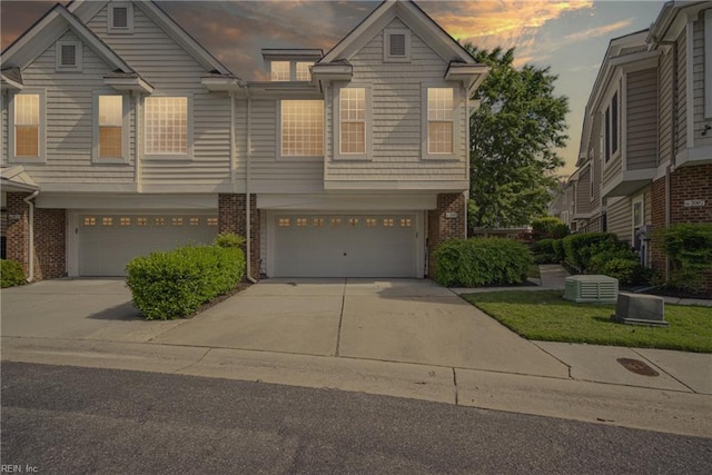 townhome / multi-family property featuring brick siding, a garage, and concrete driveway